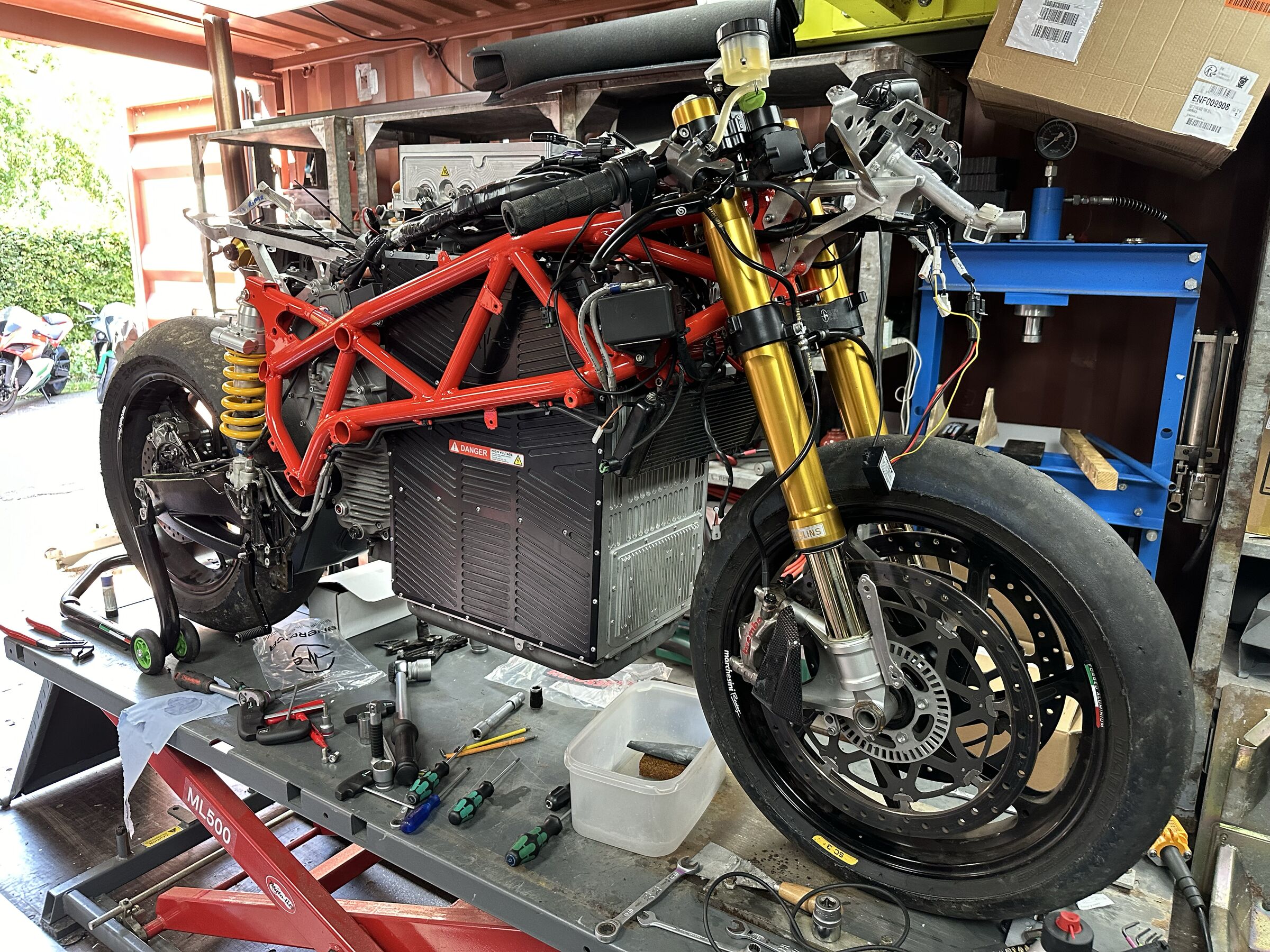 Energica Ego zonder kuip op de brug, met het gereedschap ernaast.